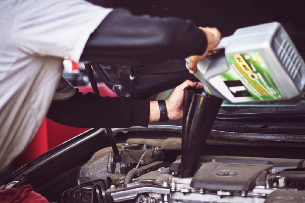 image of mechanic pouring new engine oil