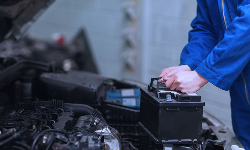 image of mechanic installing new battery