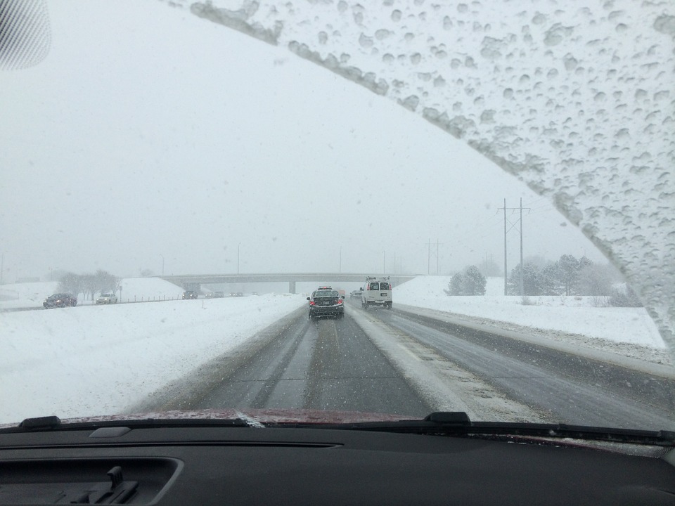 image of view out of car front windshield with ice forming on window